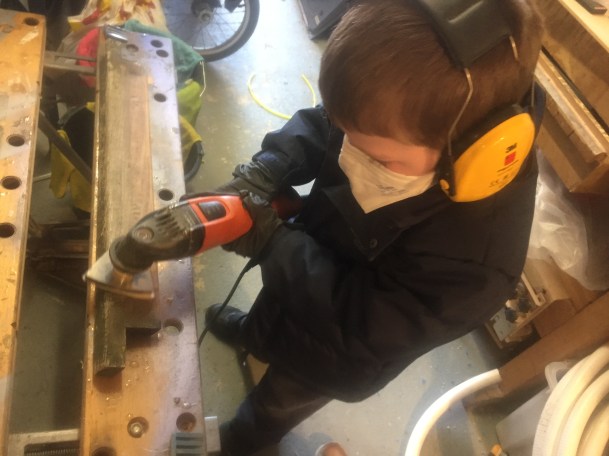 Thomas sanding the hatch trim down with the Fein multitool sporting his PPE 2