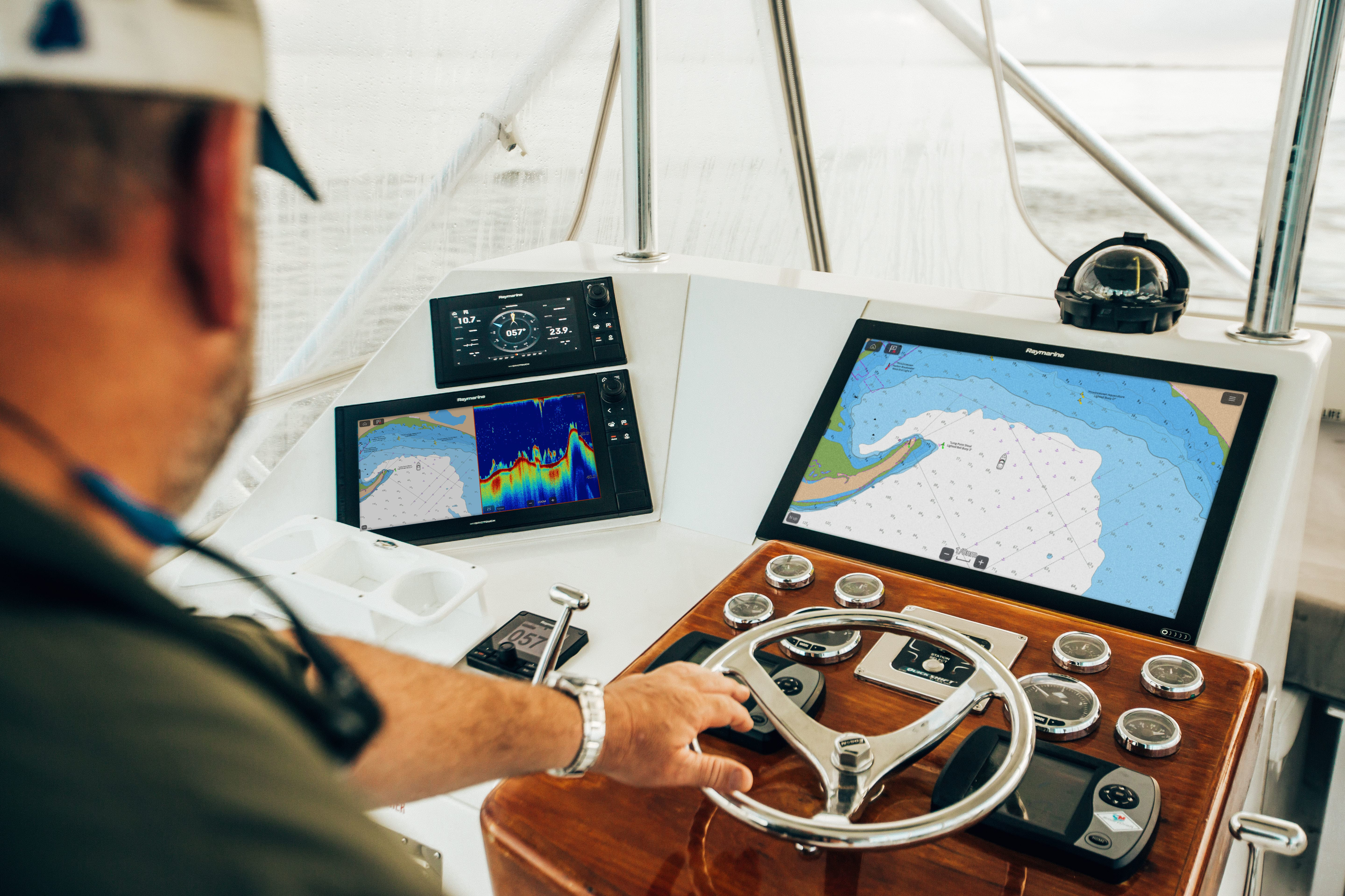 Mann navigiert Boot mit Navigationselektronik