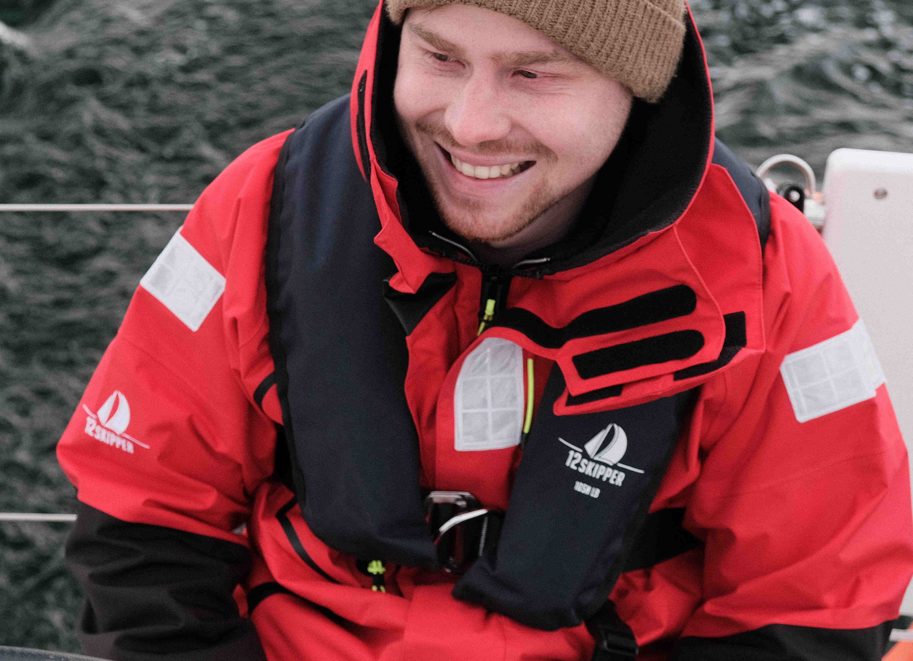 Mann mit Ölzeug testet Segelhandschuhe
