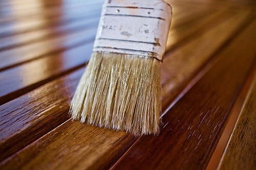 Brushing wood oil in teak furniture